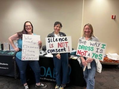 Three women holding signs