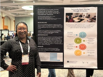 Woman standing next to a presentation poster
