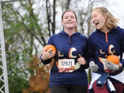 Morgan Loveday (pictured left) and a friend runs with a pumpkin
