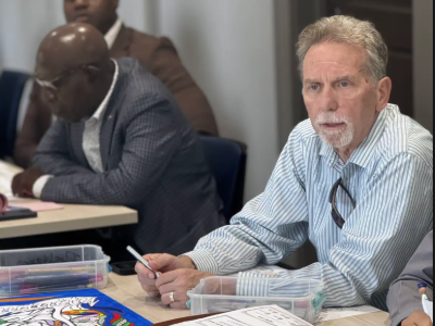 Mark Chupp sits at a table in a meeting