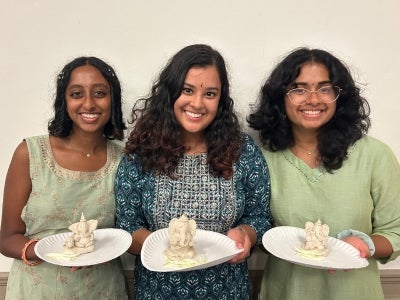 Srila Munukutla (pictured center) and friends hold clay Ganesh Chaturthi idols made at Hindu Yuva's puja before submerging them in water. 