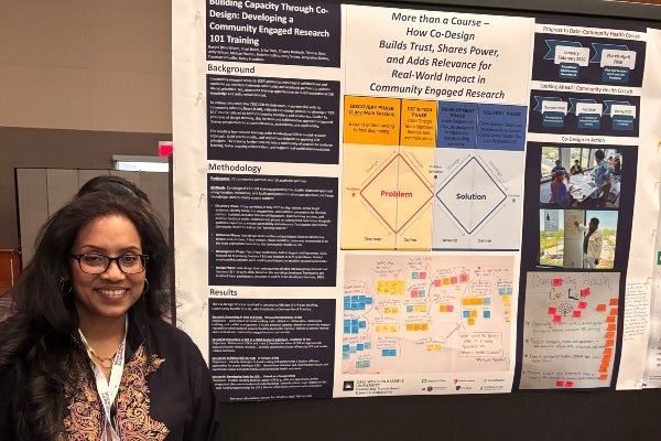 Woman standing next to a presentation poster