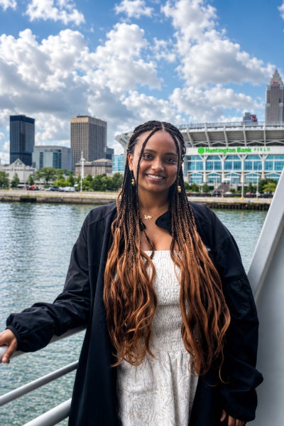 Nyat Isack standing outside with a cityscape in the background