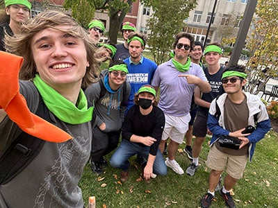 Photo of several members of the Big Games Club posing together for a selfie with bright green bandanas during a game of Humans v. Zombies