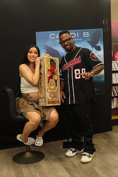 Photo of Michael Crawford with Cardi B holding one of his custom 3D-printed figures in a laser-engraved wooden box