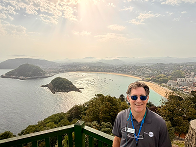 David Gerdes at a scenic overlook with a Bay in San Sebastián, Spain, in the background