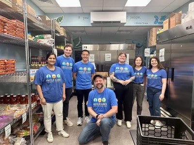 A group of Nestle employee volunteers standing in a food pantry storage area