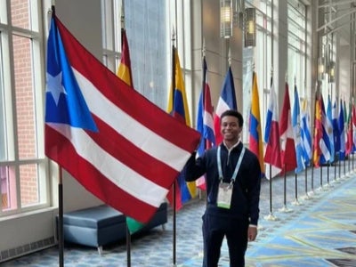 Jaral Arroyo-Jefferson poses next to Puerto Rican flag