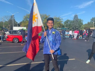 Justin Mendoza holding the national flag of the Philippines