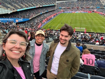 Miguel Muñoz (middle) and friends attend a soccer game. 