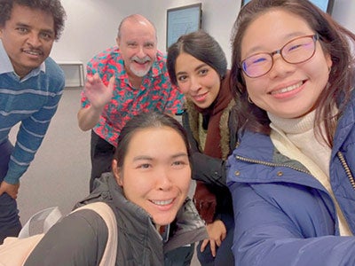 Rania Aljohani takes a selfie with classmates and a faculty member in a classroom