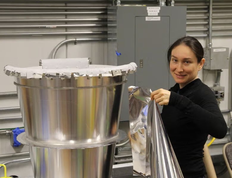 Johanna Nagy working on part of a telescope in a NASA lab.