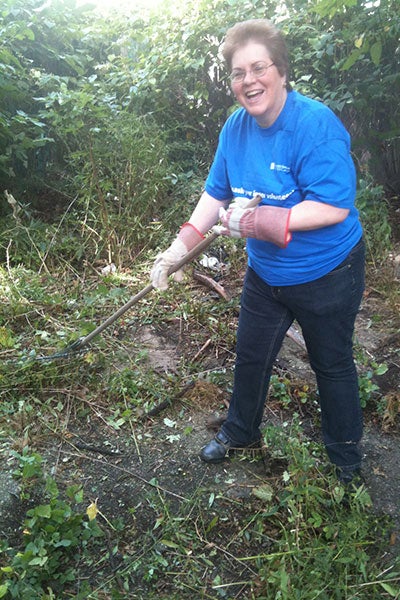 Pat Hannan holds a rake while volunteering during a CWRU community service event