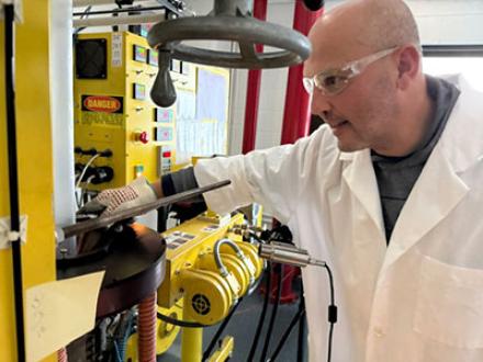 João Maia in a lab coat and safety glasses, working in his lab.