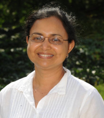 Suchitra Nelson, PhD poses in a white shirt.