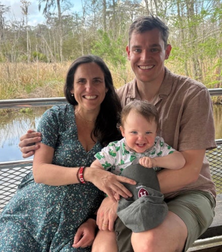 Alexander Richards riding in a boat on a bayou with his wife and child