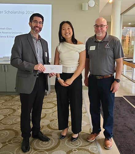 Hannah Chen accepts award with two men standing on either side of her