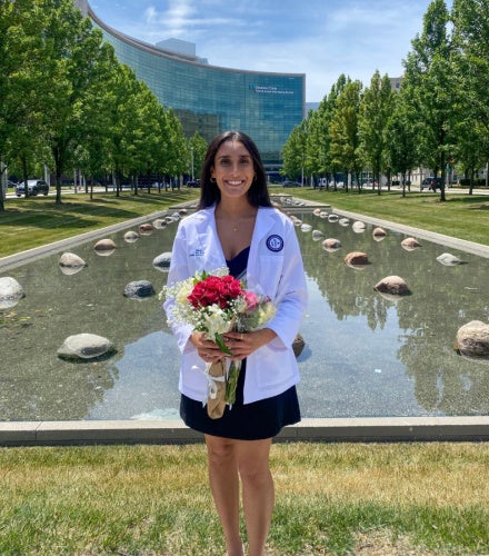 Riddhi Patel posing with flowers in front of the Cleveland Clinic