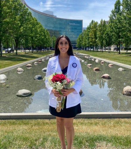 Riddhi Patel posing with flowers in front of the Cleveland Clinic