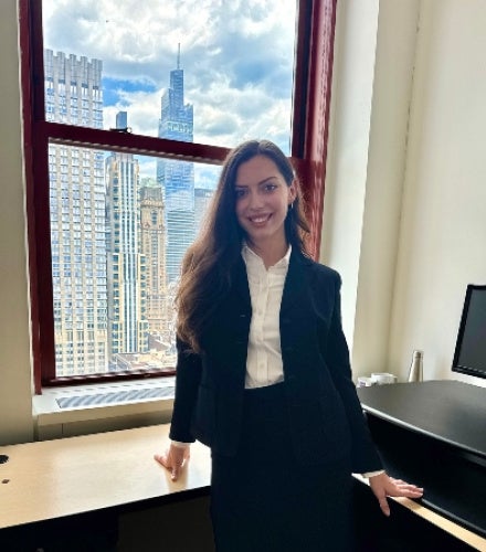 Anna Styer standing at desk in front of window in NYC