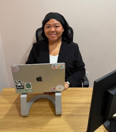 Sydney Jones sitting behind a desk with a laptop