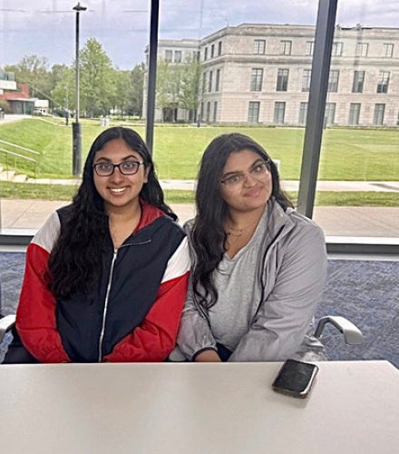 Aditi Bohre and Mahek Goel sit at a table in Tinkham Veale University Center