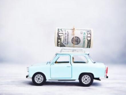 Money on top of small blue car