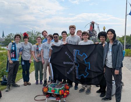 CWRUbotix team posing for a photo while holding their flag