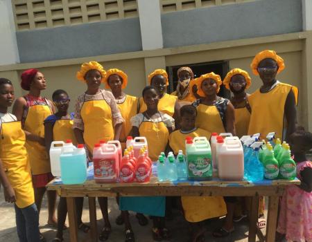 An image of a group of girls standing behind a table.