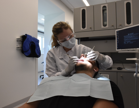 A dentist works on a patient in CWRU's dental clinic.
