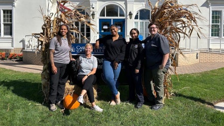 Members of the Division of Public Safety's Sexual Assault Response Team pose with a dog. 