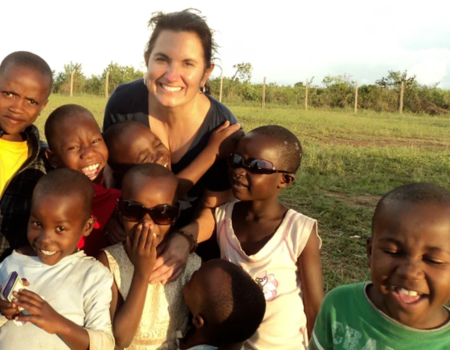 Lisa Alverto outside in Africa with young smiling children