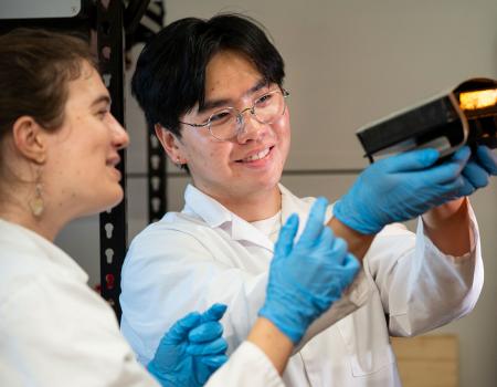 Photo of two CLEANR employees looking at a 3D printer part
