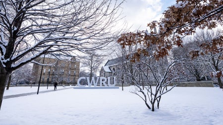 Photo of the CWRU letters on campus surrounded by snow