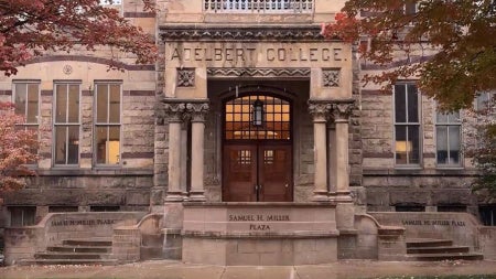 Adelbert Hall surrounded by red fall foliage with a light layer of snow. 
