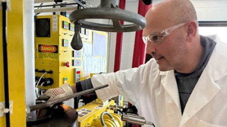João Maia in a lab coat and safety glasses, working in his lab.