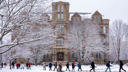 Students walk in front of Case Western Reserve University's Adelbert Hall on a snowy day