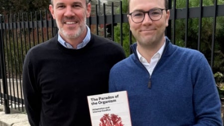 Co-editors J. Arvid Ågren and Manus M. Patten pose with their book, The Paradox of the Organism: Adaptation and Internal Conflict. 