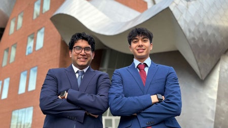 Dev Gupta and Sunveer Chugh pose for a photo in front of the Peter B. Lewis Building