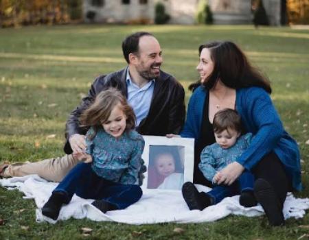 Tony and Laura Corsi posing with their two children, as well as a picture of their son Luca who passed away