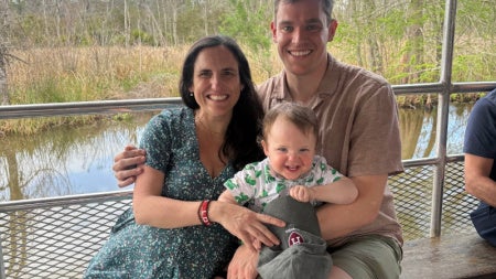 Alexander Richards riding in a boat on a bayou with his wife and child