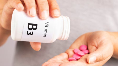 Close up of hands holding Vitamin B3 pills