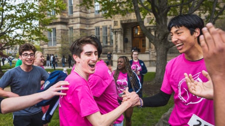 Students celebrate after the Hudson Relays while wearing bright pink shirts