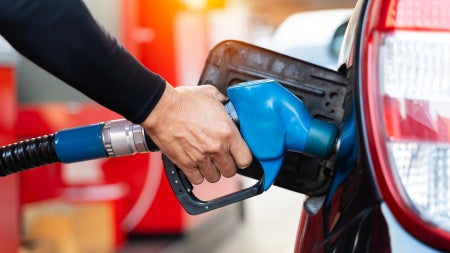 A person fills their car with gas