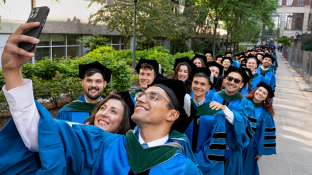 2026 MD students taking a selfie while lining up for commencement