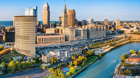 Photo of the Cleveland skyline on a bright sunny day with the Cuyahoga River in the foreground