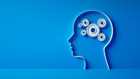 3D silhouette of a head with gear mechanics symbol against blue wall 