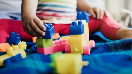 Kindergarten-aged child plays with colorful blocks