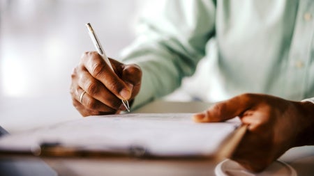 Close up of a person signing paperwork