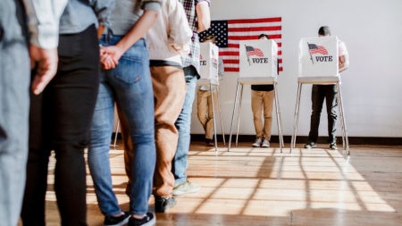 People in line wait at voting booths